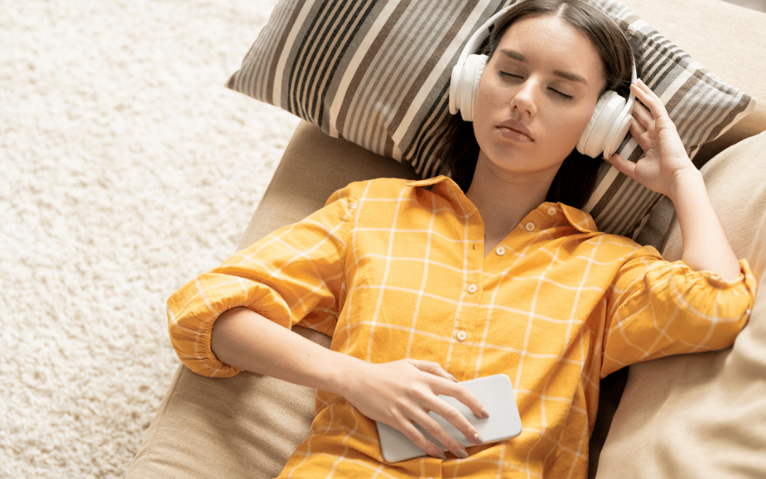 Young women laid down relaxing earing headphones